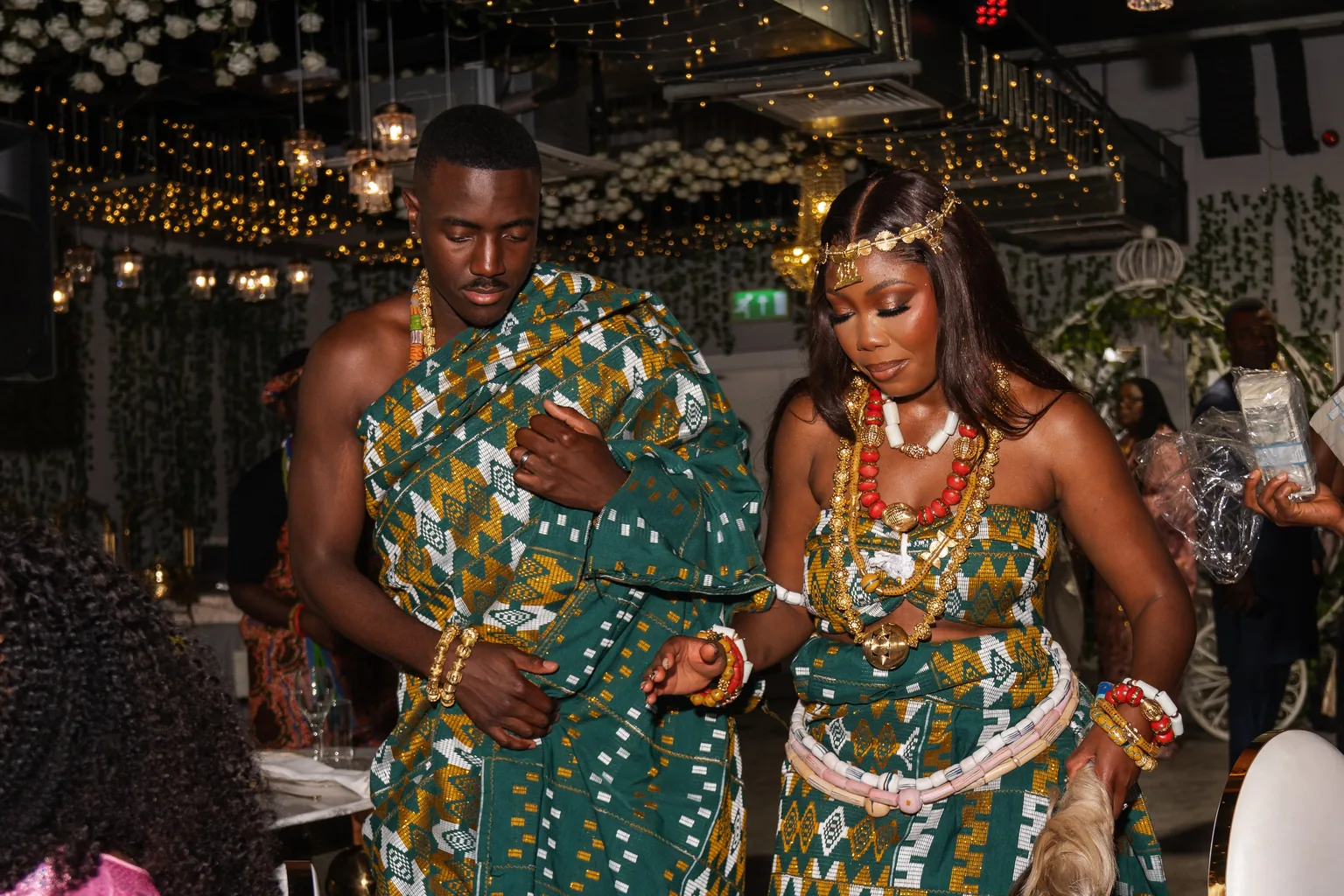 A couple in traditional wedding attire sharing a dance